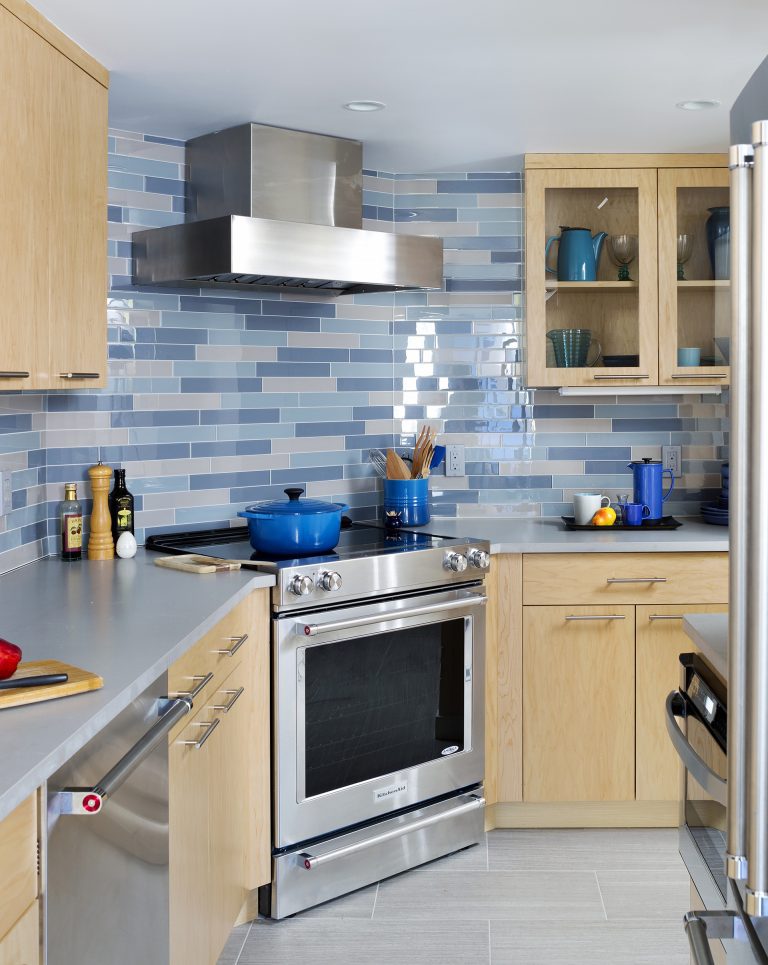 modern dc kitchen light wood cabinetry upper cabinets with glass doors blue tile backsplash stainless steel appliances