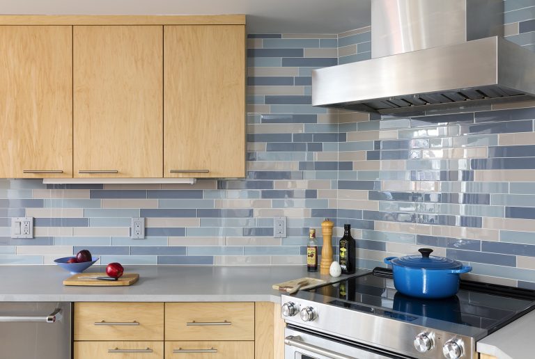 modern dc kitchen light wood cabinetry blue tile backsplash stainless steel electric range and hood