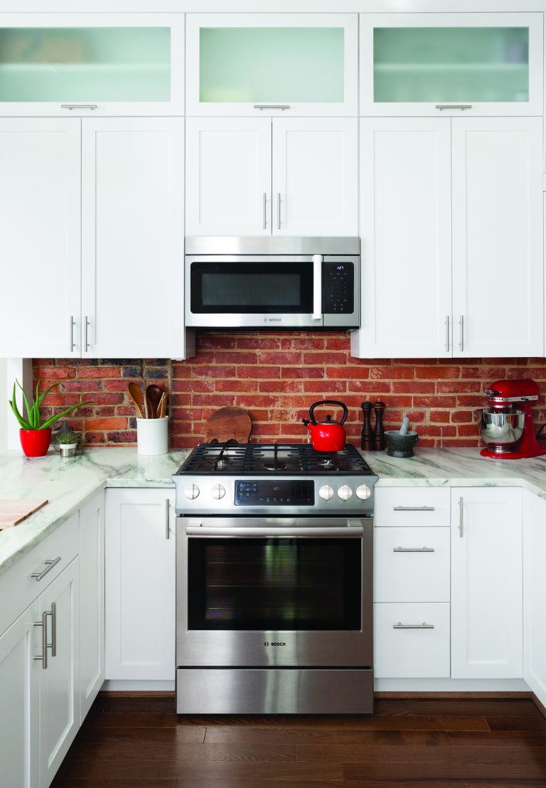 DC kitchen dark hardwood floors white cabinets frosted glass upper cabinets red brick backsplash