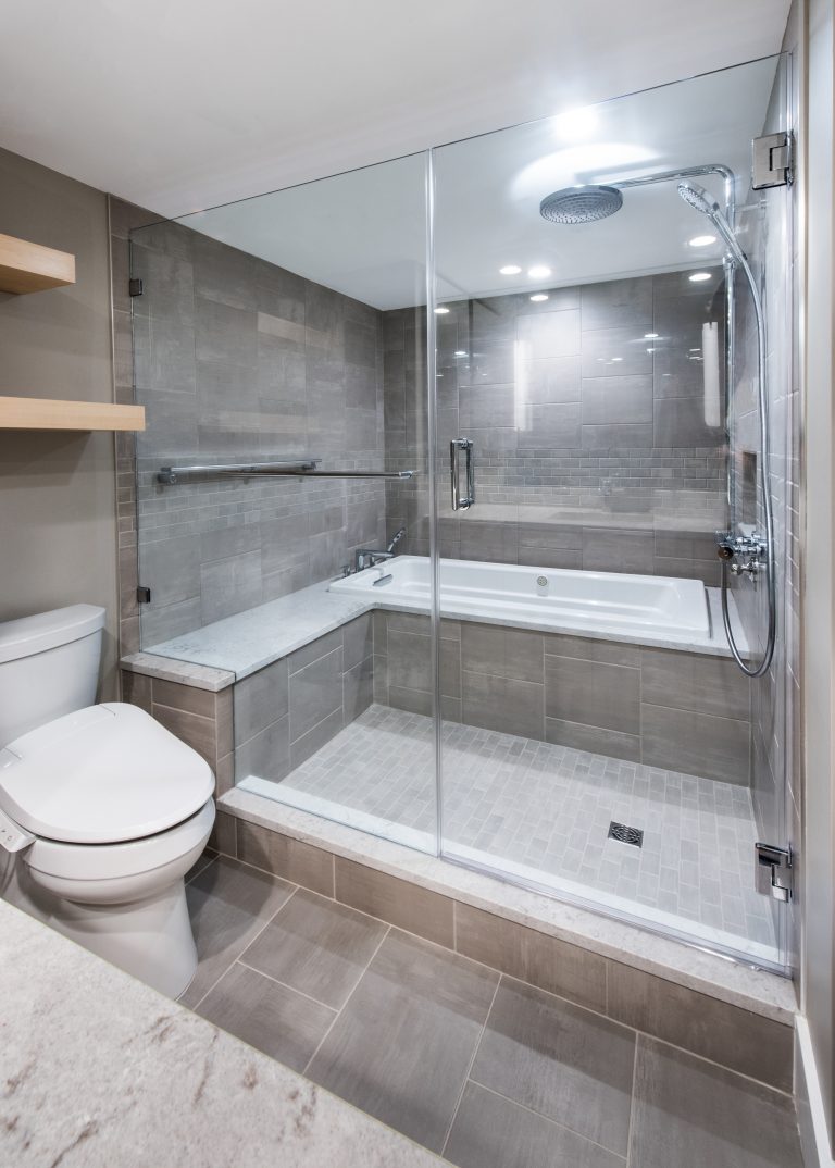 gray bathroom large shower with glass wall and built in bench