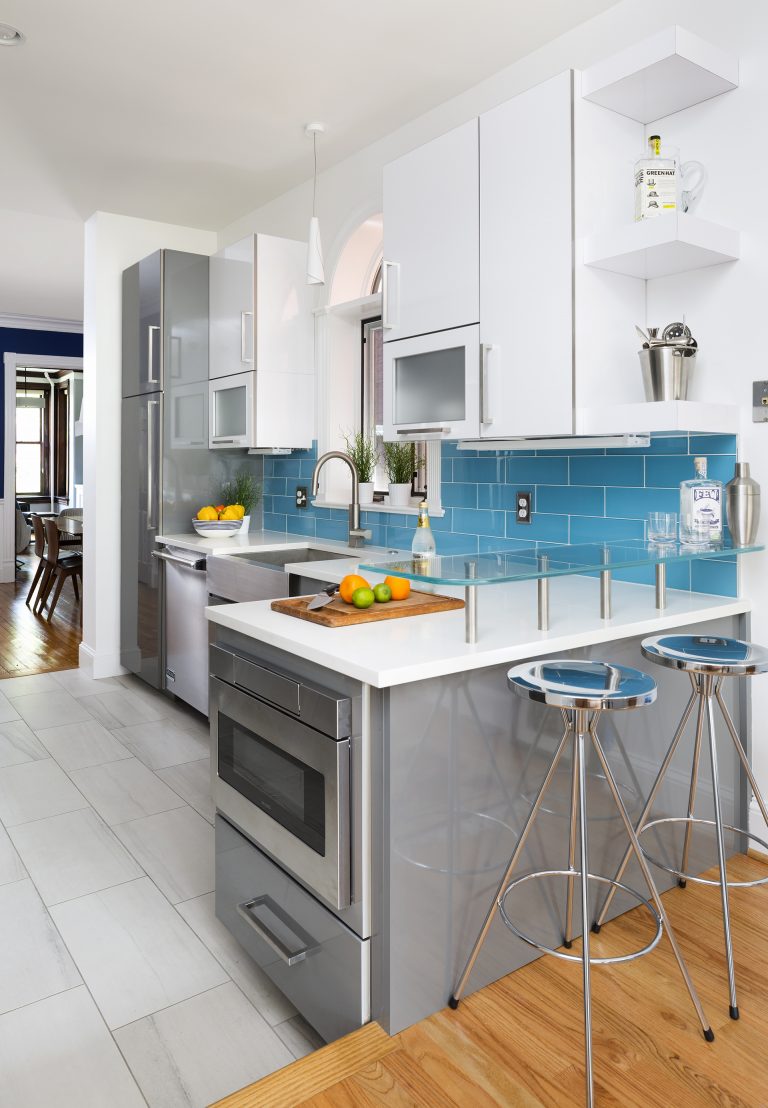 gray and white cabinetry blue tile in modern kitchen peninsula with seating