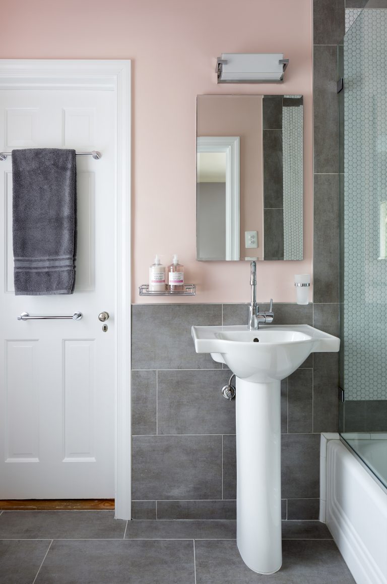 porcelain sink with chrome faucet neutral toned pink walls and gray tile