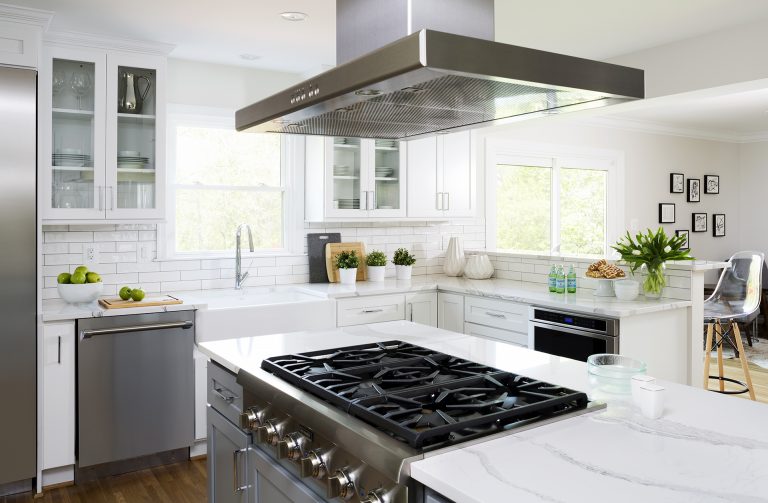 gas stovetop built into island with stainless steel hood kitchen open to living area