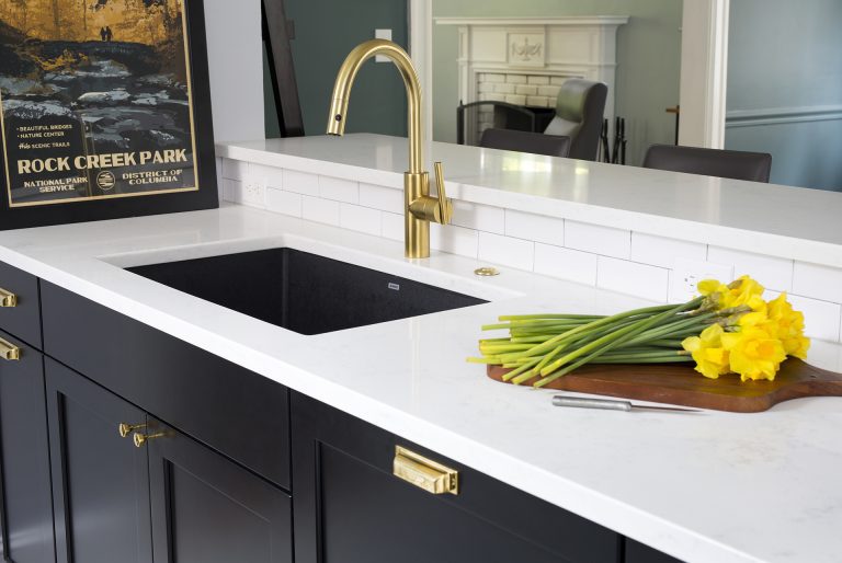 sink area with gold fixtures and cabinetry hardware