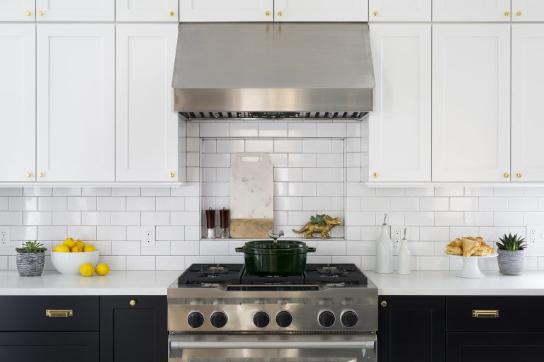 stainless steel gas range and hood subway tile backsplash with built in nook