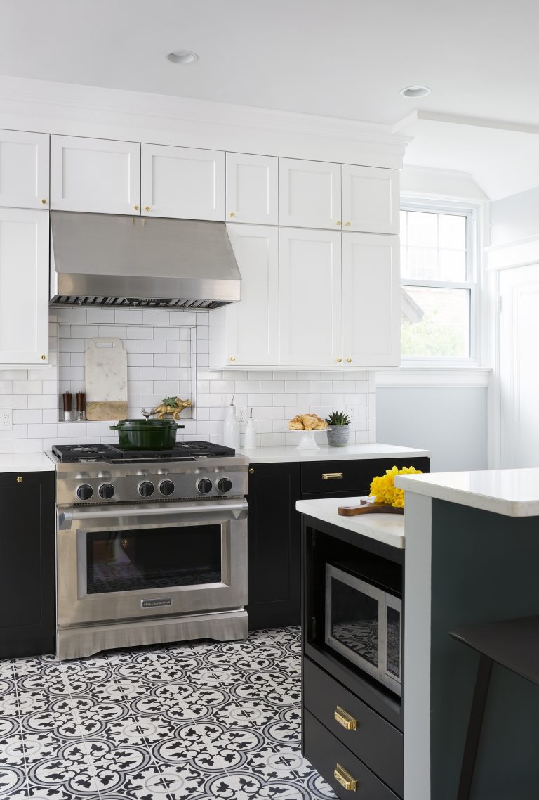 stainless steel gas range and hood black and white patterned tile floors bar height peninsula seating