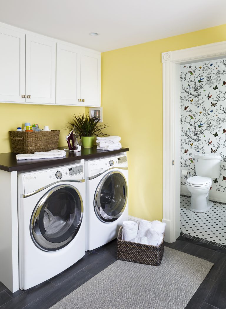 yellow laundry room white cabinetry wood floors plenty of storage