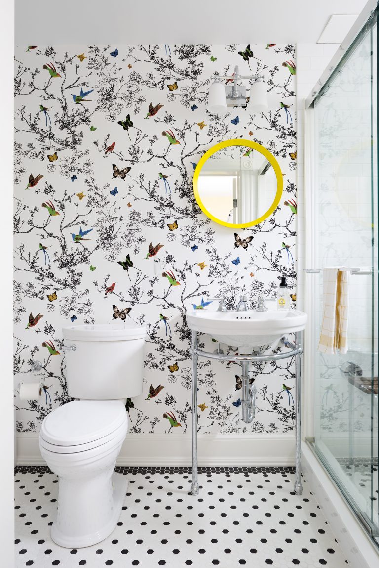bright bathroom with butterfly wallpaper glass door shower sink with exposed pipes black and white floor