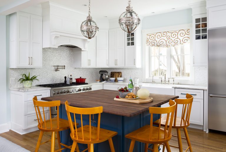 navy blue island cabinetry with seating and pendant lighting