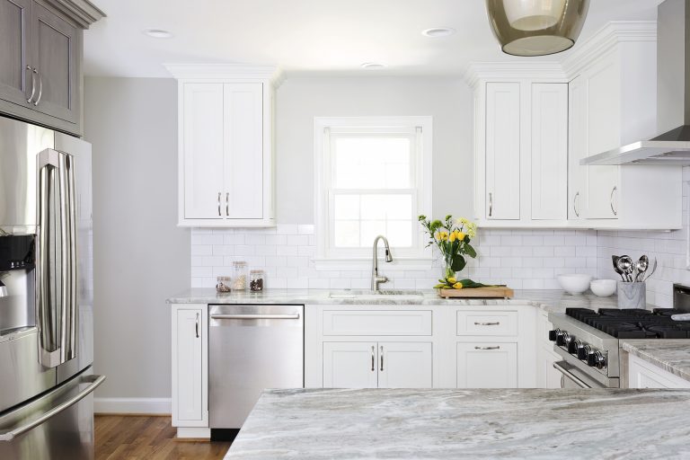 bright white kitchen with stainless steel appliances and peninsula with seating