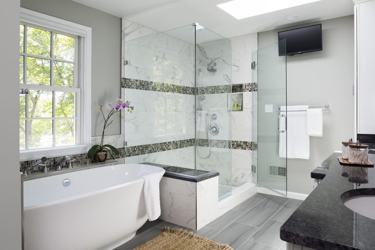 overview of renovated bathroom separate tub and shower natural color palette green tones and skylight
