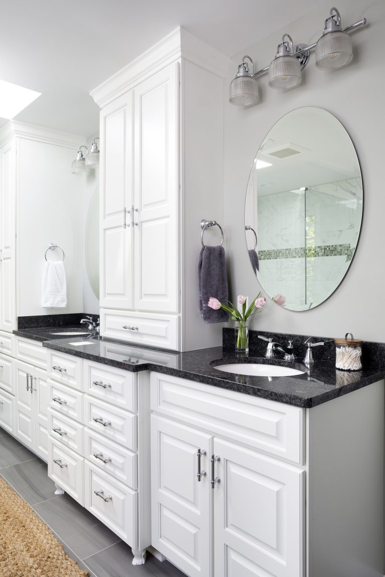 double sink vanity with white cabinetry black countertop plenty of storage sconce lighting