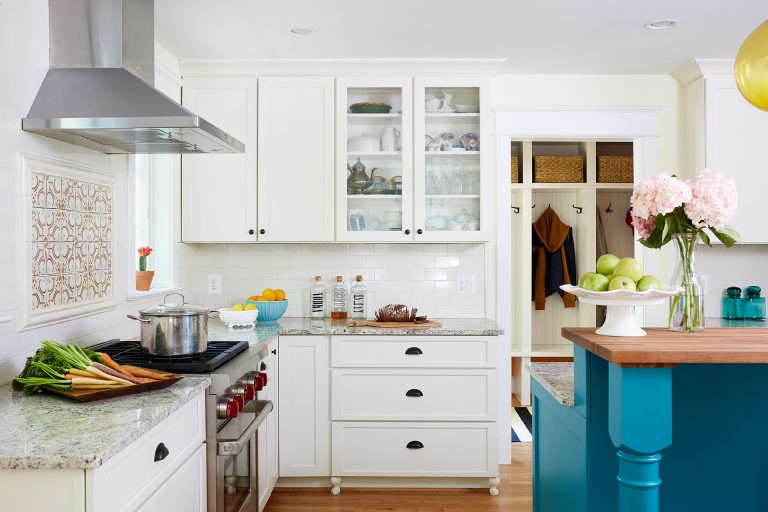 white kitchen with teal island glass door upper cabinets wood floors