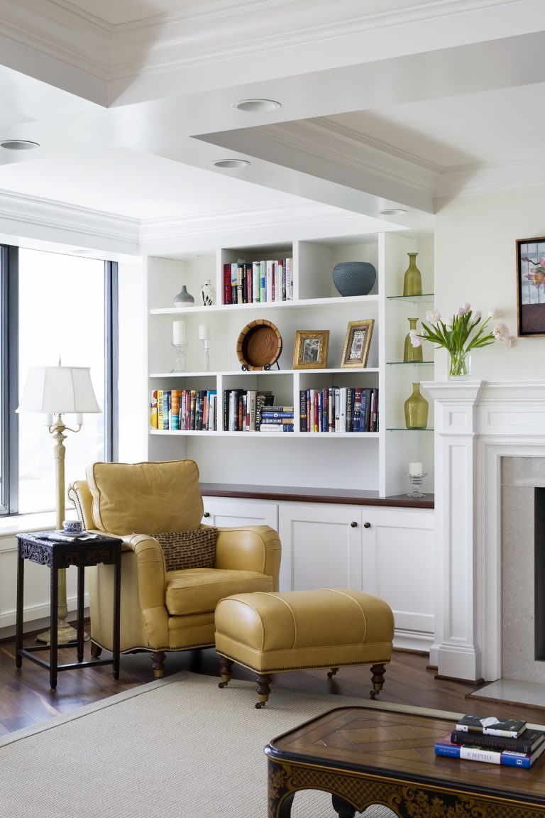 living area with large windows built in storage and shelving coffered ceiling