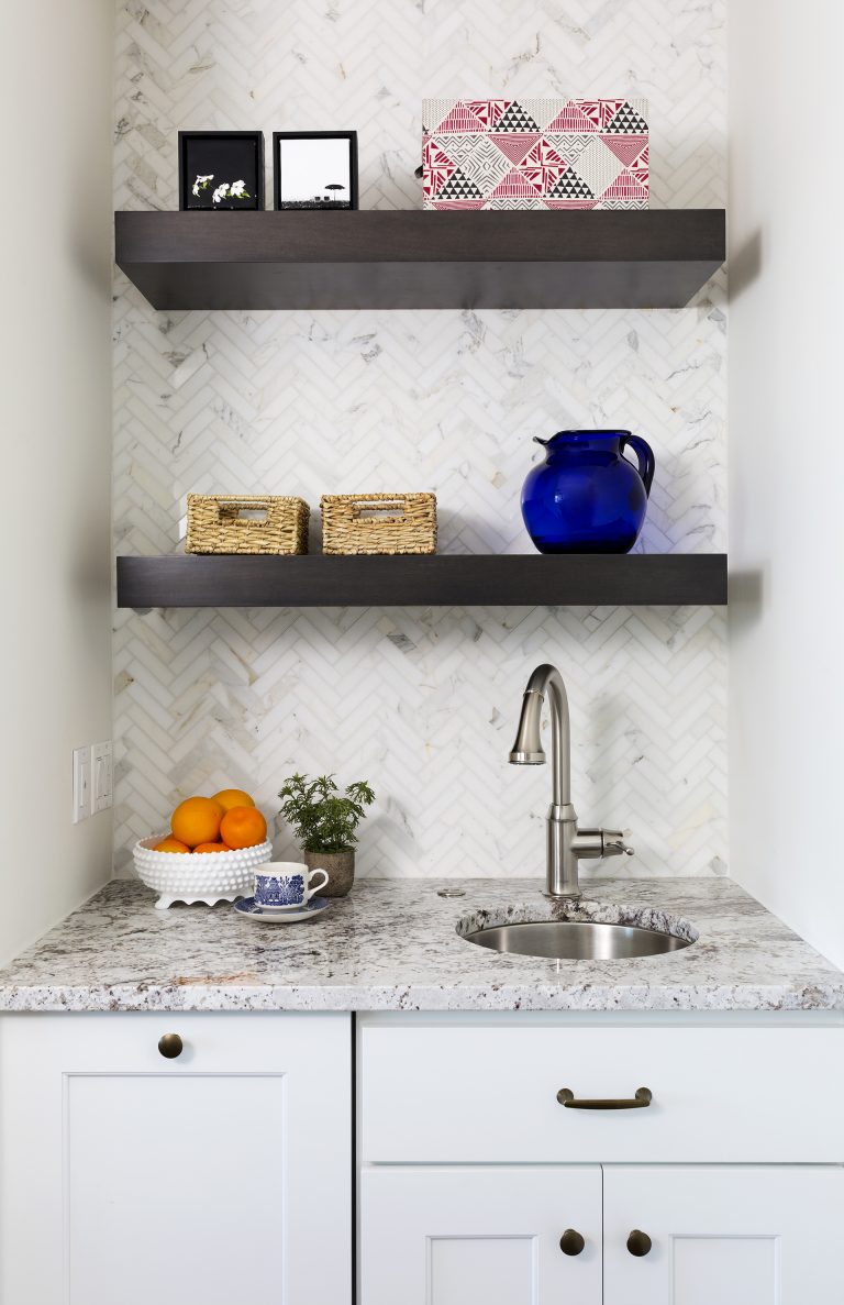 bar sink area in craftsman kitchen with open shelving above and backsplash tile to ceiling