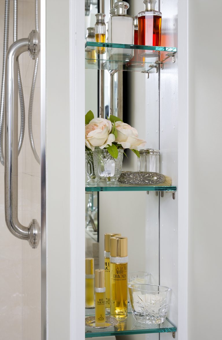 glass shelf storage in bathroom with mirror behind