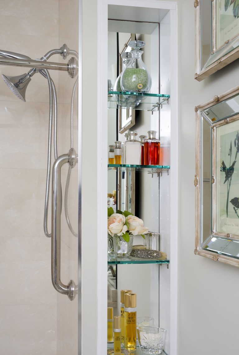 glass shelf storage in bathroom with mirror behind