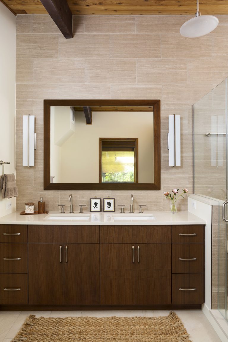 sleek bathroom brown and neutral color palette double sink vanity separate shower stall with glass door tile feature wall exposed wood ceiling