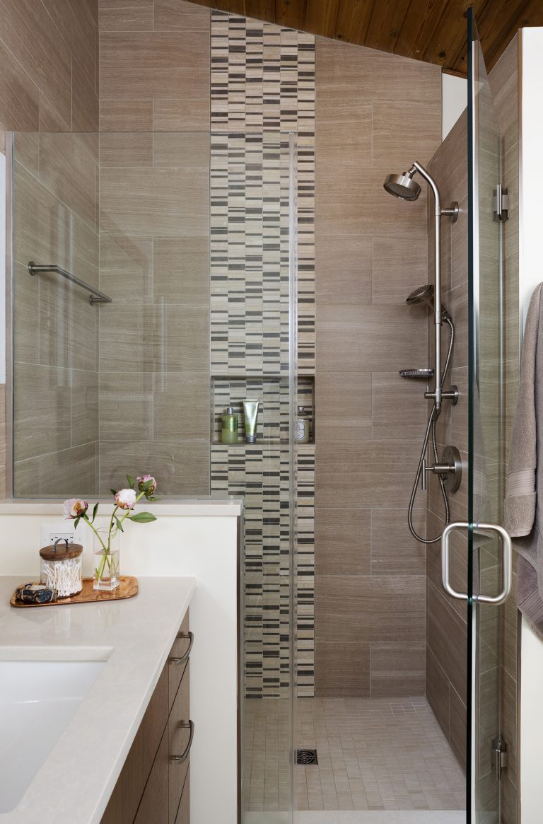 separate shower stall with glass door and built in storage nook tile detail wood ceiling