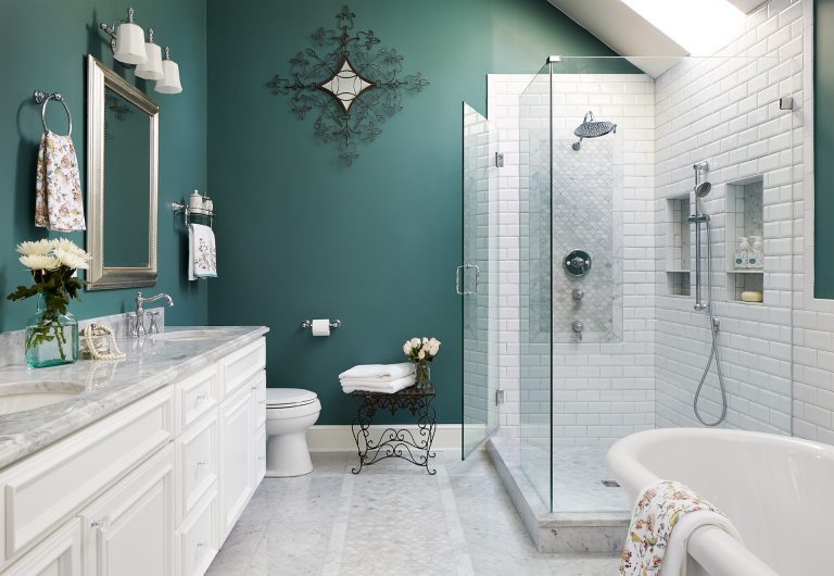bathroom with teal walls vanity with white cabinetry and double sinks separate tub and shower skylight