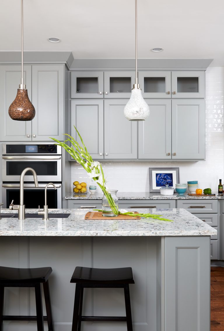 kitchen with gray cabinetry pendant lighting seating at island stainless steel wall oven