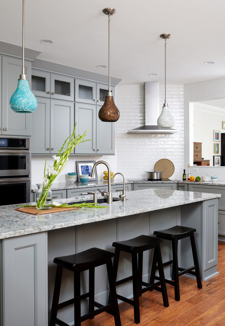 kitchen with wood floors gray cabinetry glass uppers island with seating and pendant lighting
