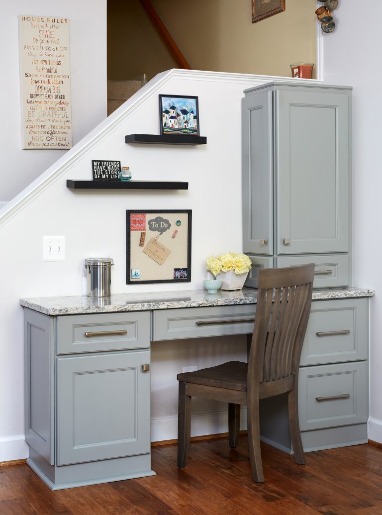 built in desk area with gray cabinetry and open shelving