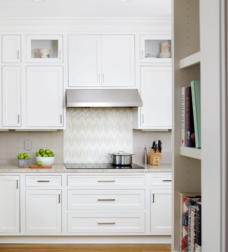 electric stovetop and stainless steel hood with backsplash tile detail