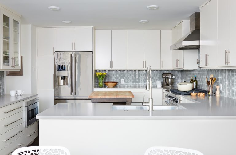 overview of kitchen white and soft blue color palette peninsula with seating