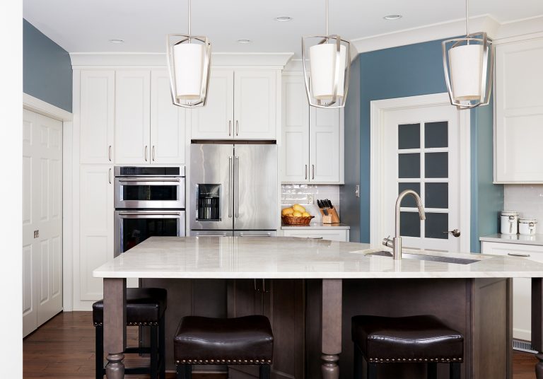 kitchen with blue walls white cabinets center island with seating pendant lighting