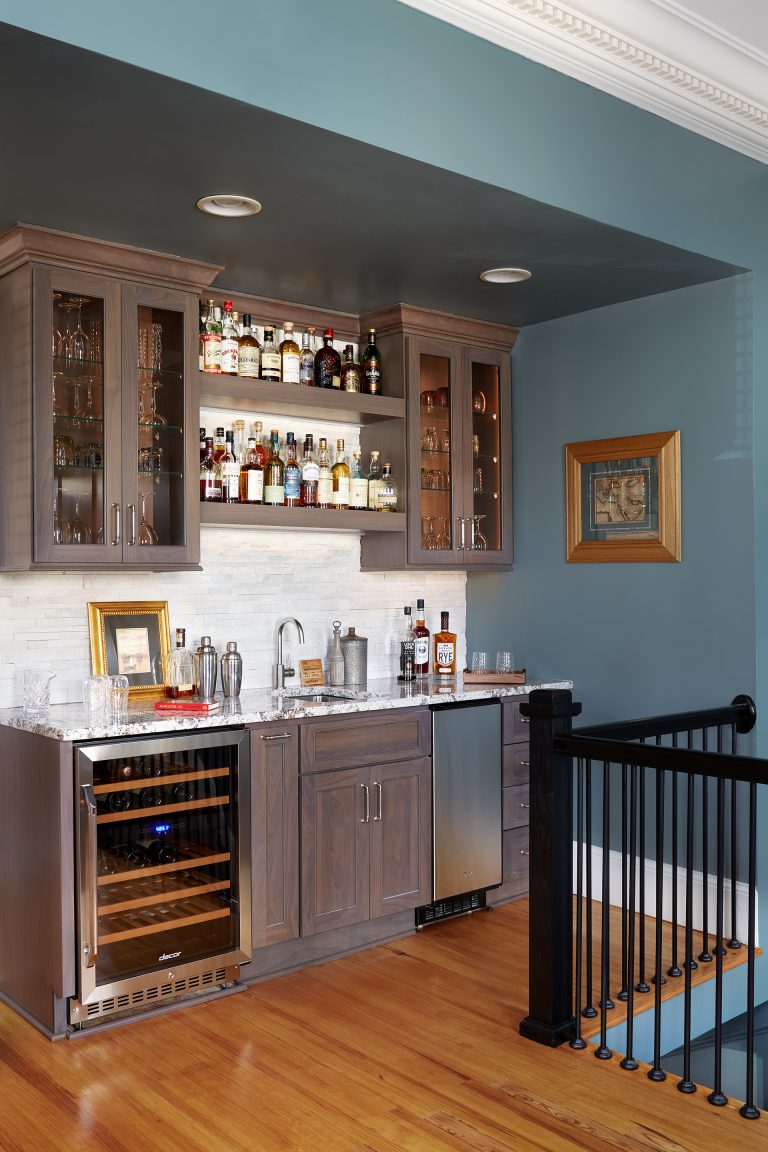indoor bar area stainless steel mini refrigerators open shelving and upper cabinets with glass doors blue walls