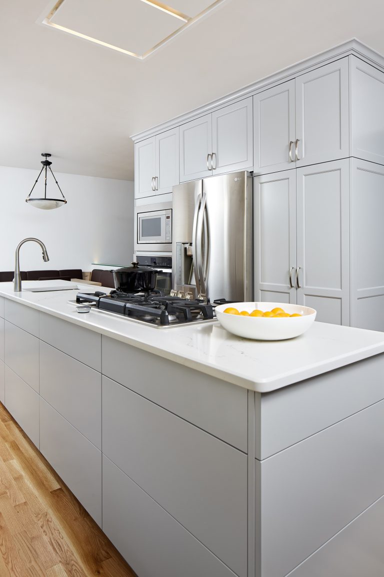 kitchen with white cabinetry and countertops stovetop and sink in island