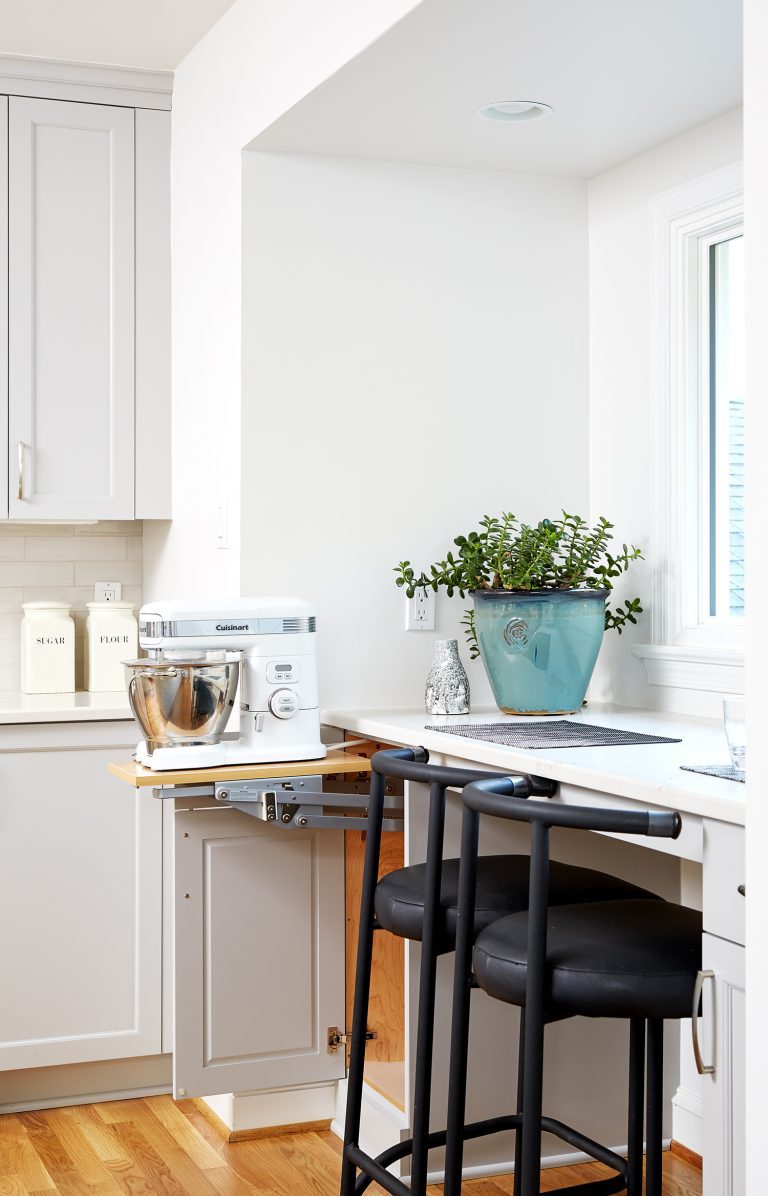 white kitchen with bar height seating in front of window