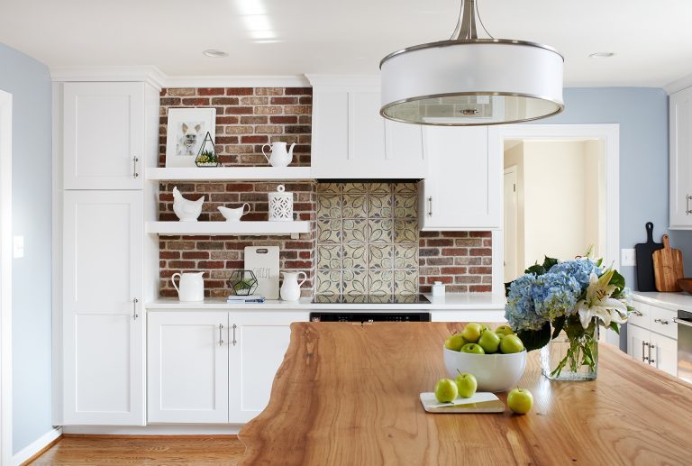 wooden top kitchen island exposed brick wall with open shelving