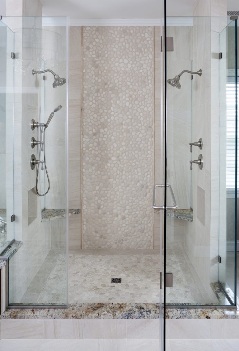 large shower stall with glass walls built in bench and storage nook dual shower heads