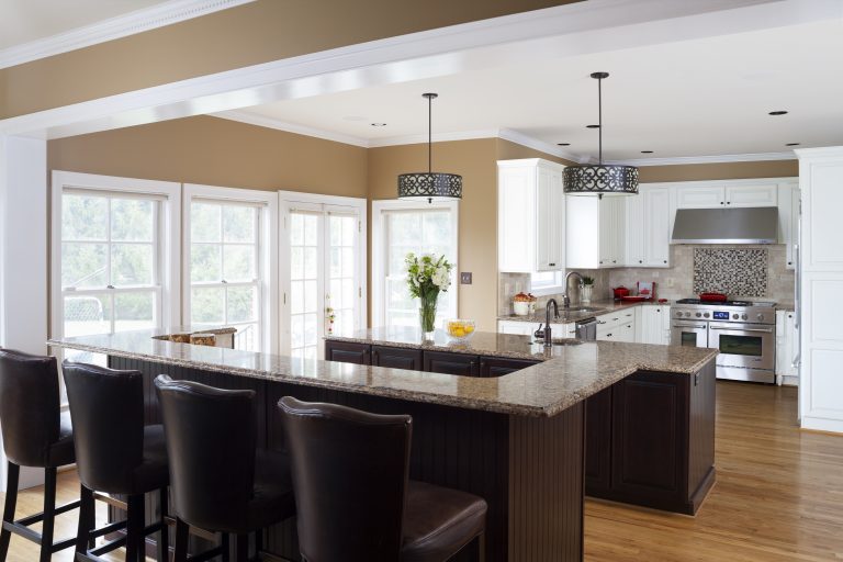 kitchen with beige walls lots of windows island with dark wood cabinetry and bar height seating