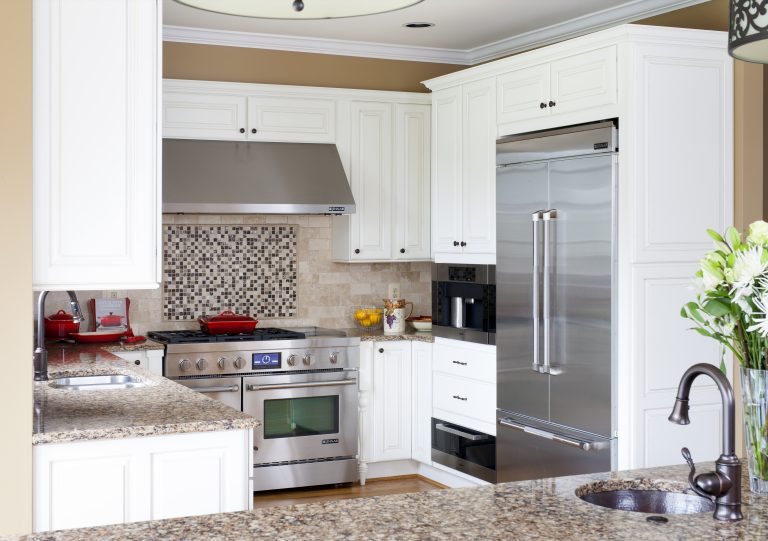 kitchen with beige walls white cabinetry stainless steel range and hood with mosaic tile backsplash detail