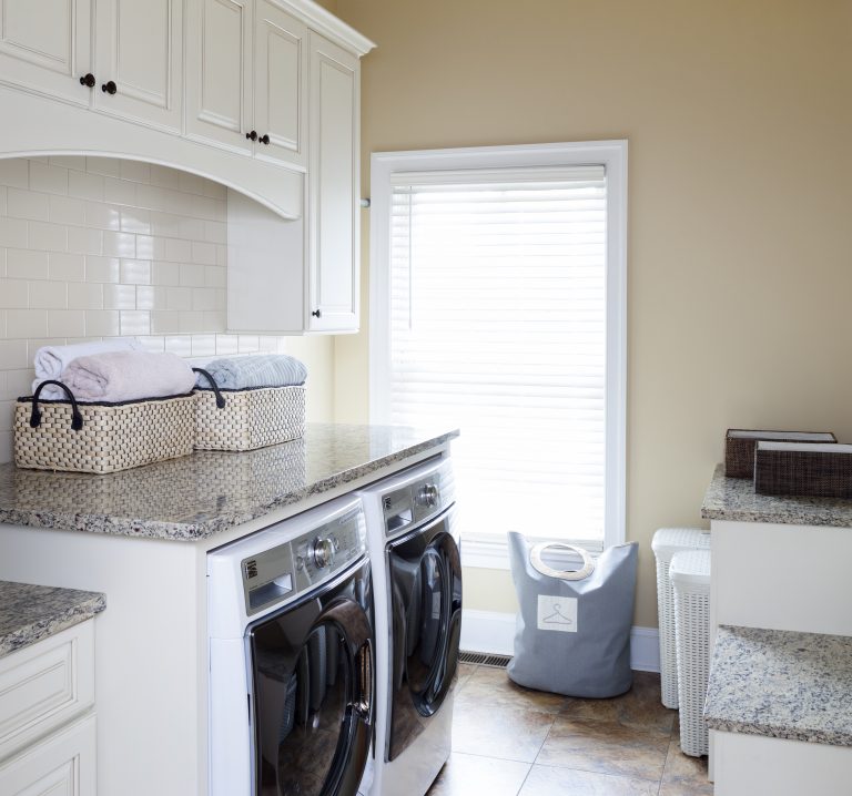 renovated laundry room with counter space and white cabinetry subway tiling on wall