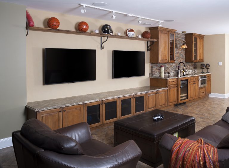 basement man cave entertainment center with open shelving and minibar area with beverage refrigerator