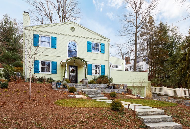 Exterior of yellow house with blue shutters