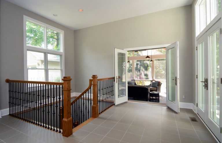 staircase up to hallway with double glass doors to living area and outdoor space large window tile floors