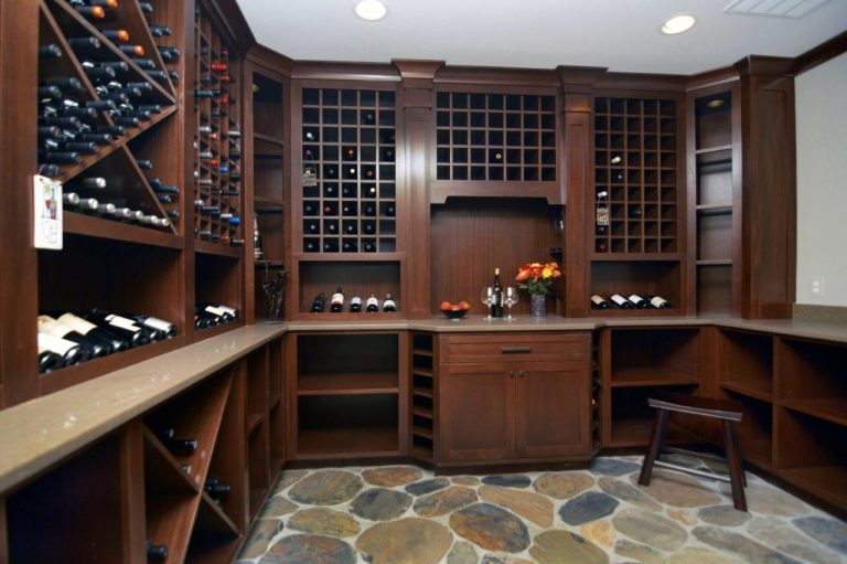 wine cellar with stone floors dark cabinetry plenty of wine storage recessed lighting