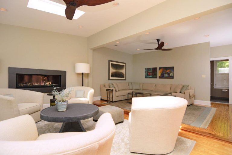 renovated living area white walls and skylight light wood floors and modern fireplace
