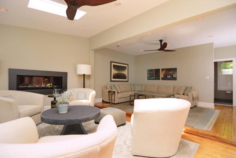 renovated living area white walls and skylight light wood floors and modern fireplace