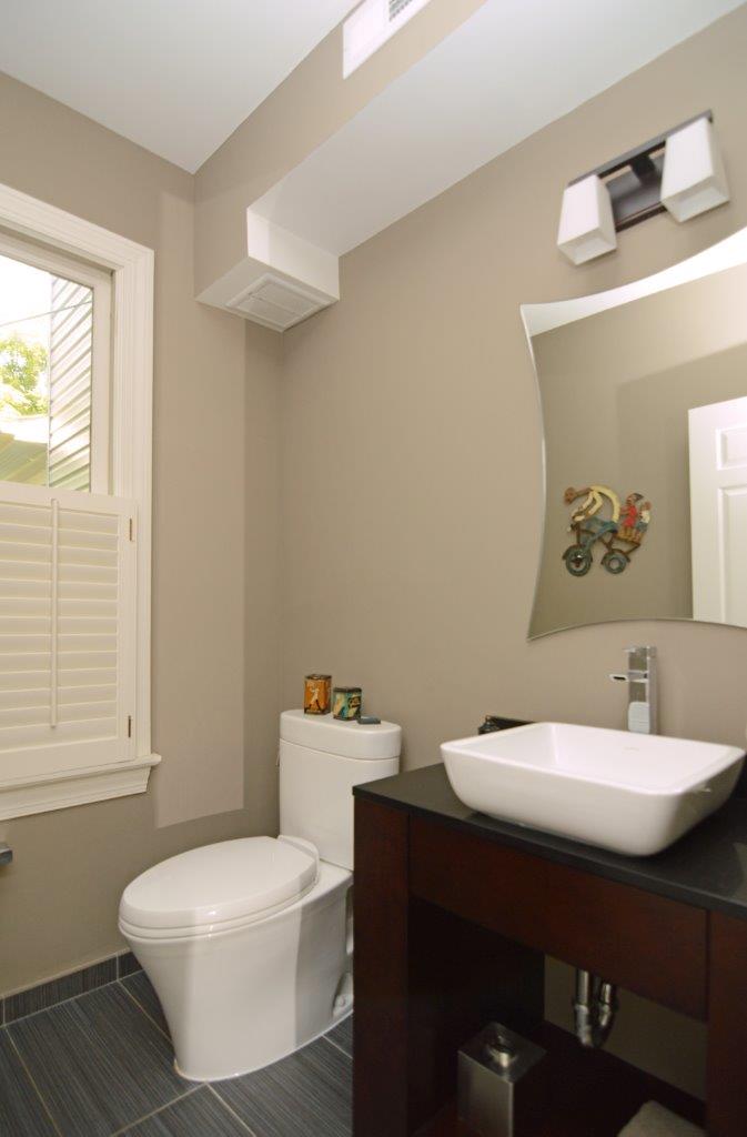 beige bathroom with square basin sink and sconce lighting