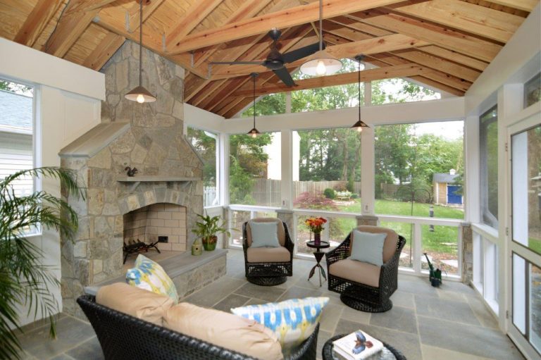 screened in porch addition with stone fireplace and wood ceiling with beams flagstone floors