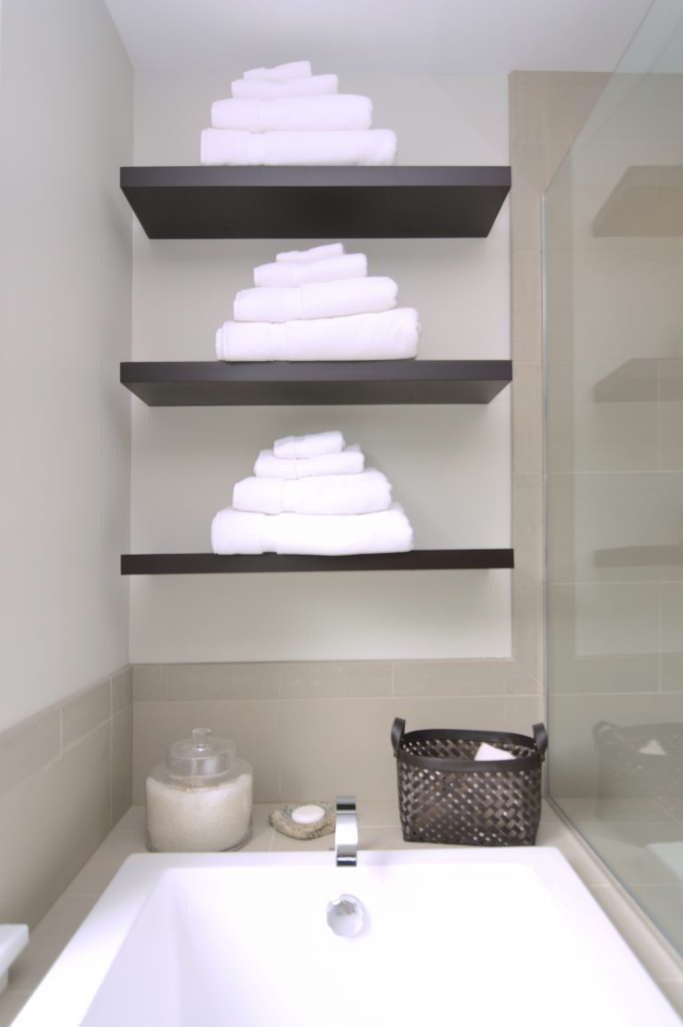 bathtub with glass wall divider and open shelving