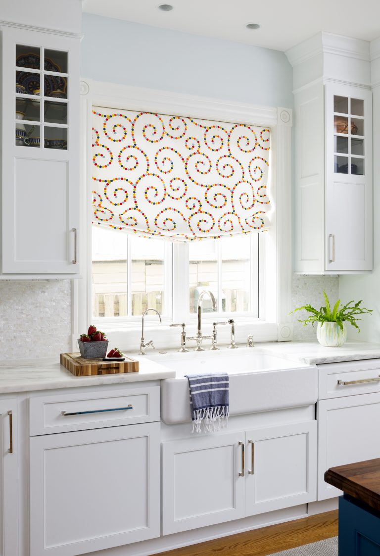 white kitchen porcelain farmhouse sink in front of window cabinetry with glass door uppers