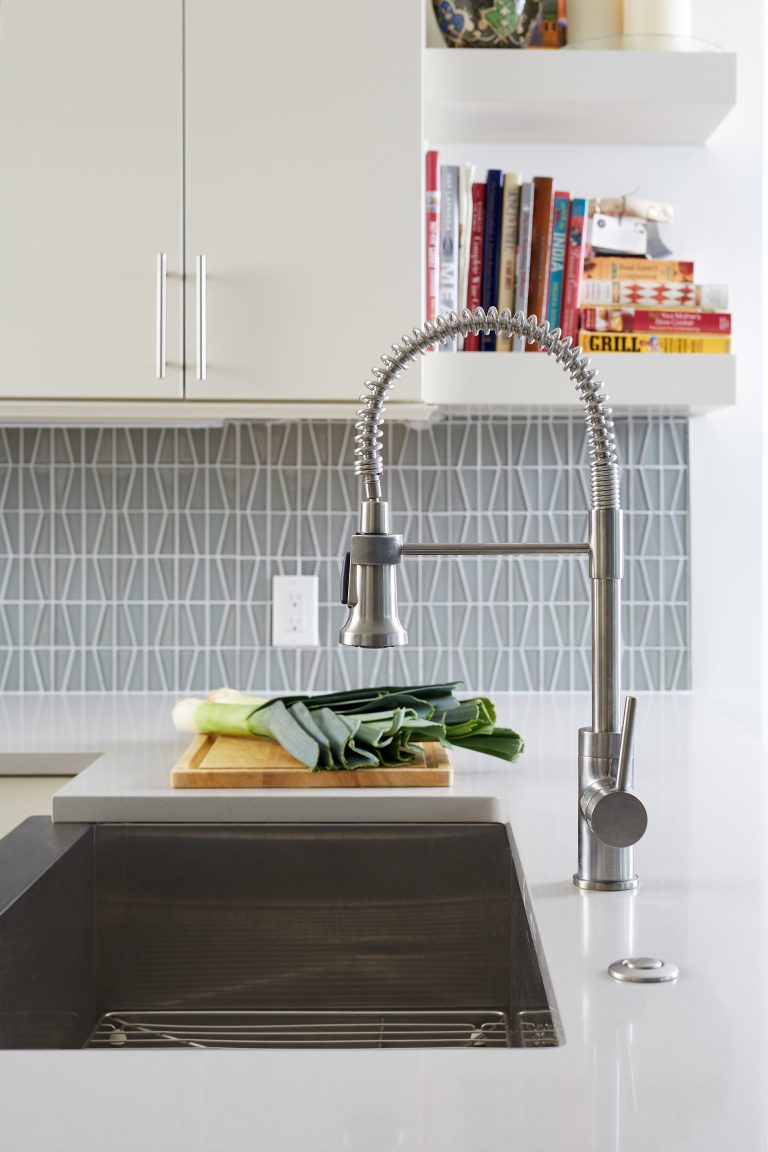 side view of kitchen peninsula sink and cabinetry with open shelving on end