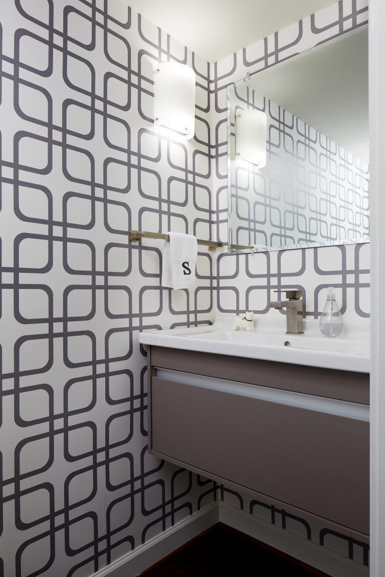 bathroom sink with floating vanity and geometric wallpaper